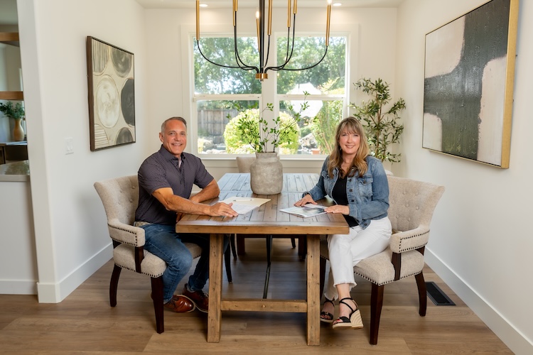 Two First Street Real Estate agents seated at a dining table in a bright, modern home.
